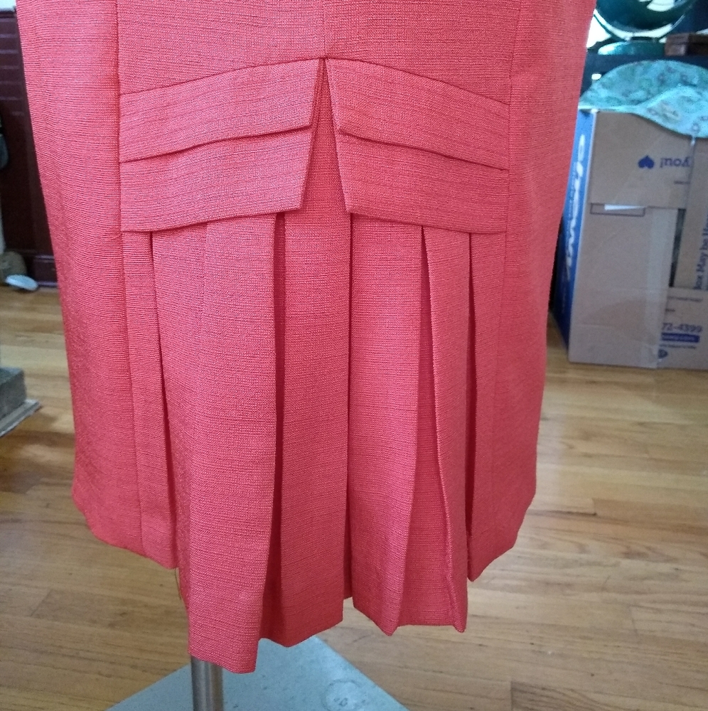 Deep Coral pencil skirt with intricate kick pleat.
